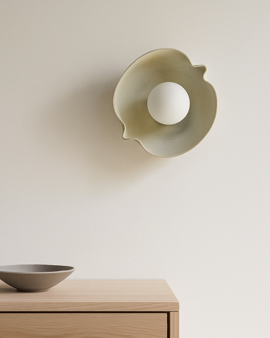 Decorative wall sconce and bowl on a wooden surface with a neutral background