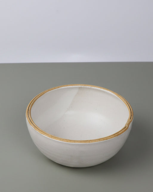 White ceramic bowl with split rim on a gray background