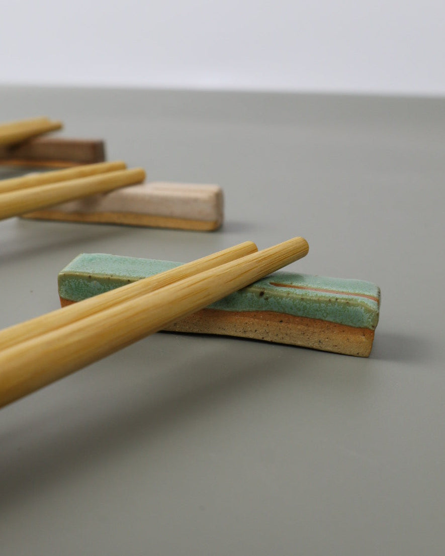 Set of wooden sticks with different colors on a light gray background