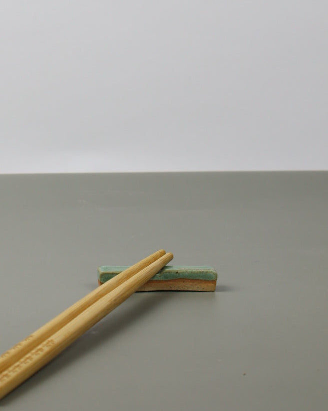 chopsticks restng on a ceramic rest