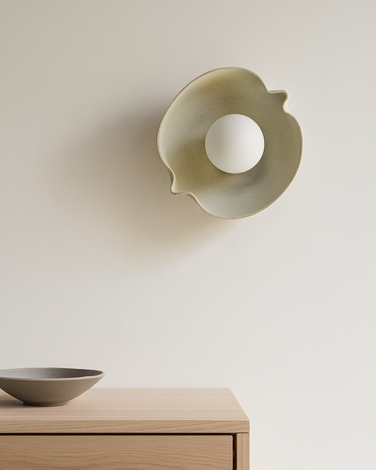 Decorative wall sconce and bowl on a wooden surface with a neutral background