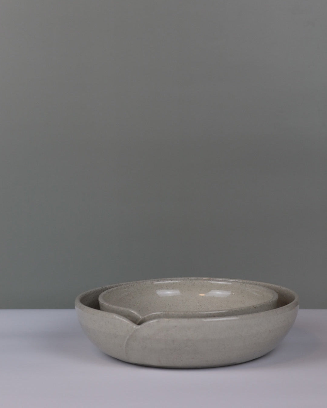 Ceramic bowl on a gray background with smaller bowl nesting inside