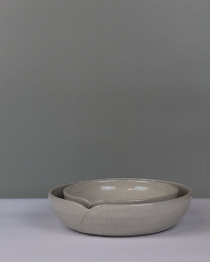 Ceramic bowl on a gray background with smaller bowl nesting inside
