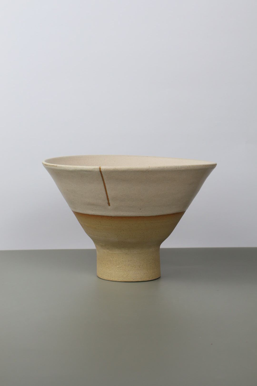 pedestal ceramic noodle bowl on a grey surface