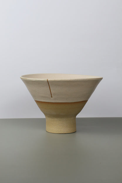 pedestal ceramic noodle bowl on a grey surface