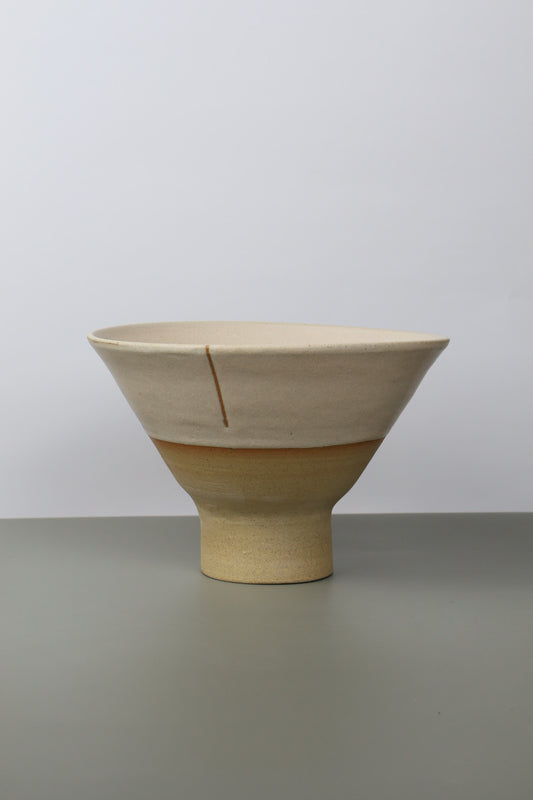 pedestal ceramic noodle bowl on a grey surface