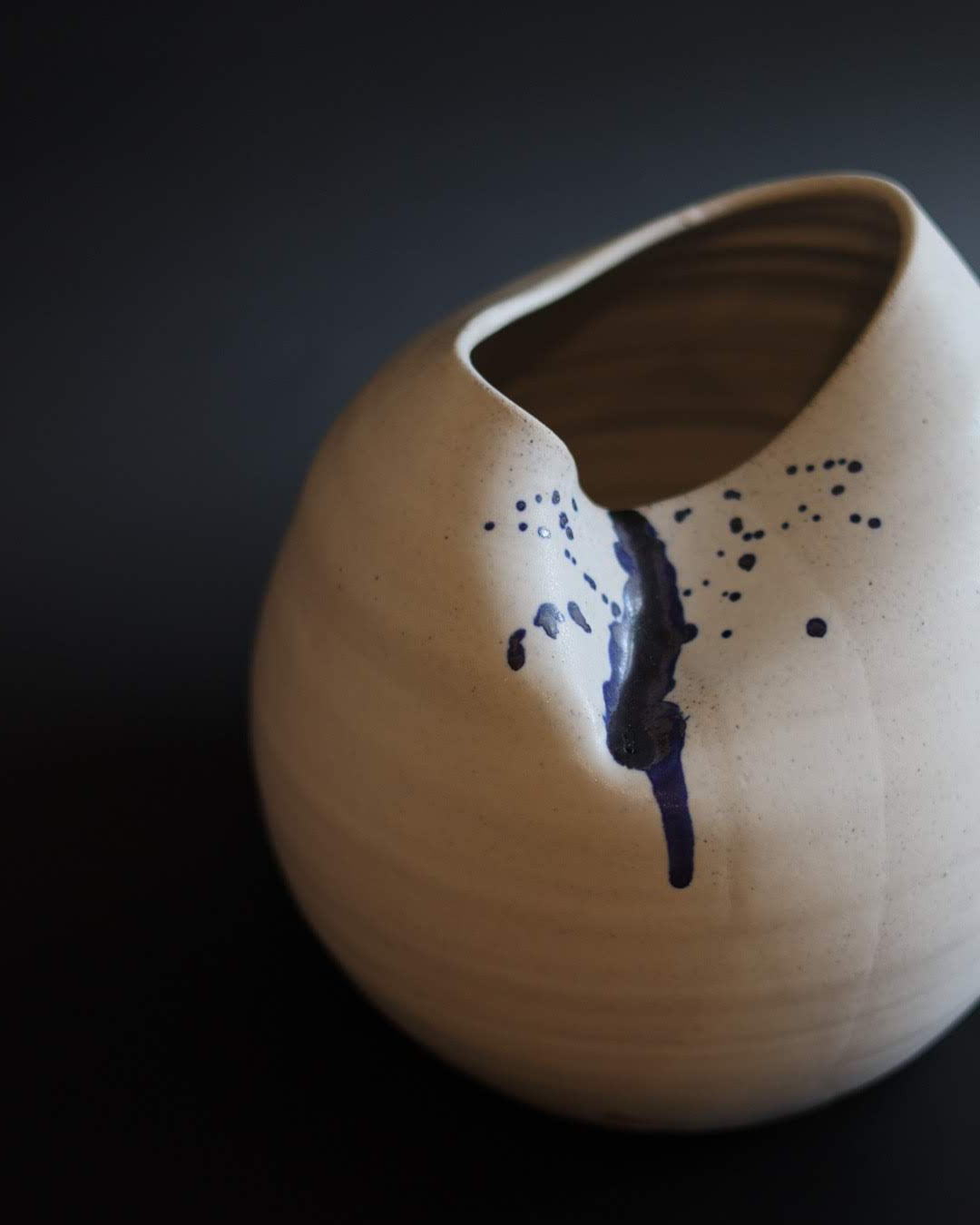 Ceramic vase with blue abstract design on a dark background
