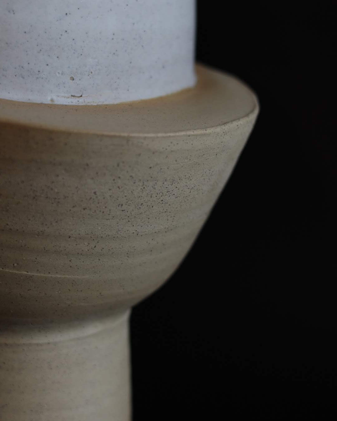 Close-up of a ceramic sculpture with a textured surface on a black background