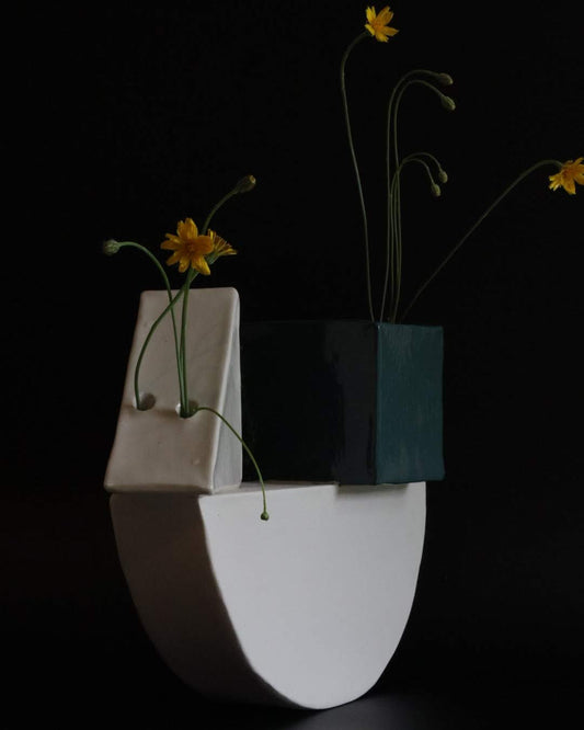 Abstract ceramic art piece with geometric shapes and flowers on a black background