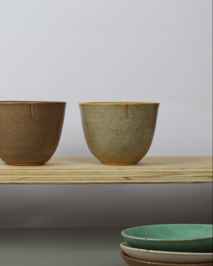 set of eramic teacups on a wooden shelf