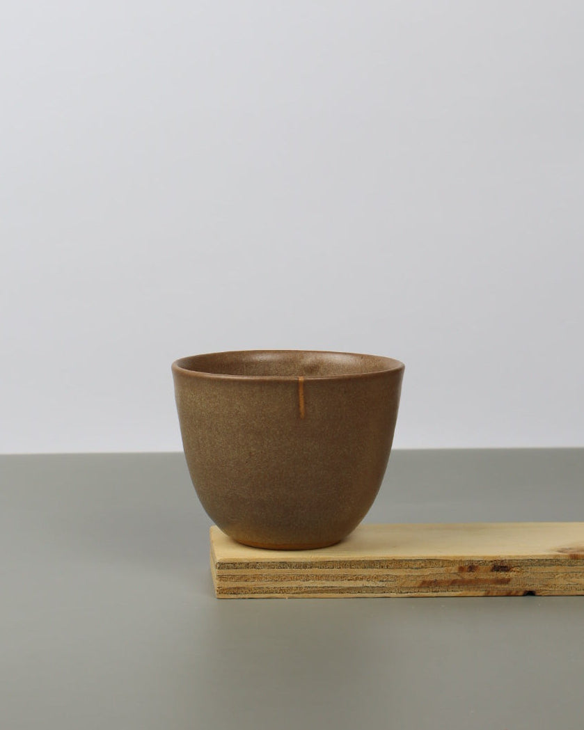 Brown teacup on a wooden shelf