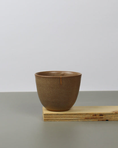 Brown teacup on a wooden shelf