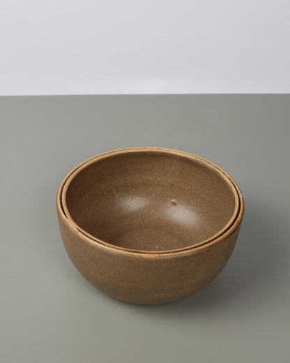 Brown ceramic bowl on a gray background