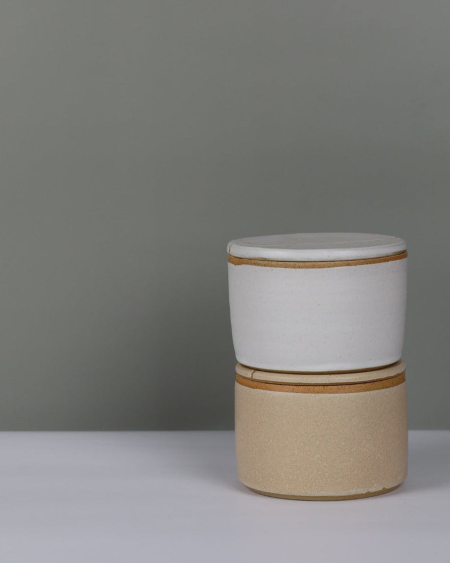 stack of two ceramic butter bells on a grey background