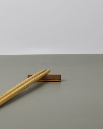 chopsticks resting on a ceramic chopstick rest