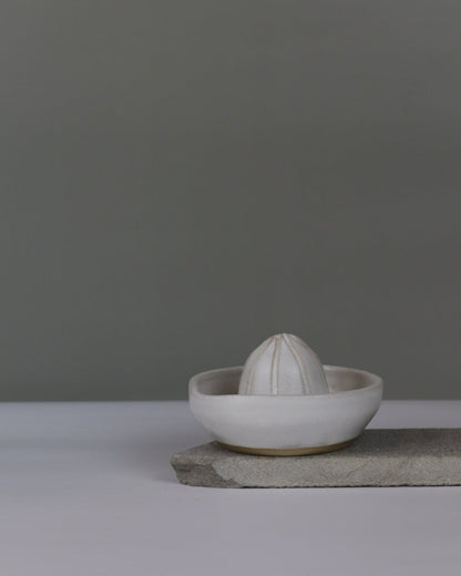 white ceramic citrus juicer on a grey background