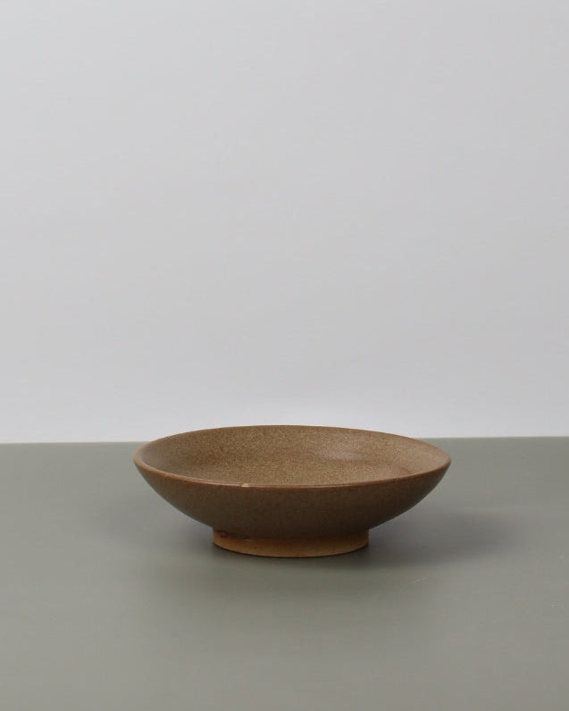 brown ceramic dish on a grey table