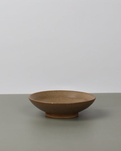 brown ceramic dish on a grey table