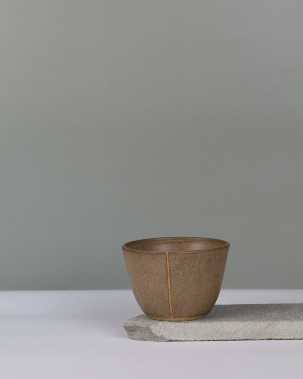 small brown bowl on a grey background