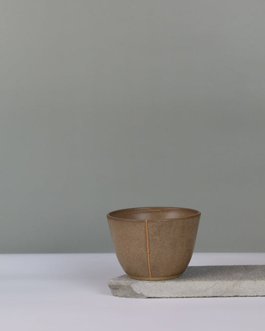 small brown bowl on a grey background
