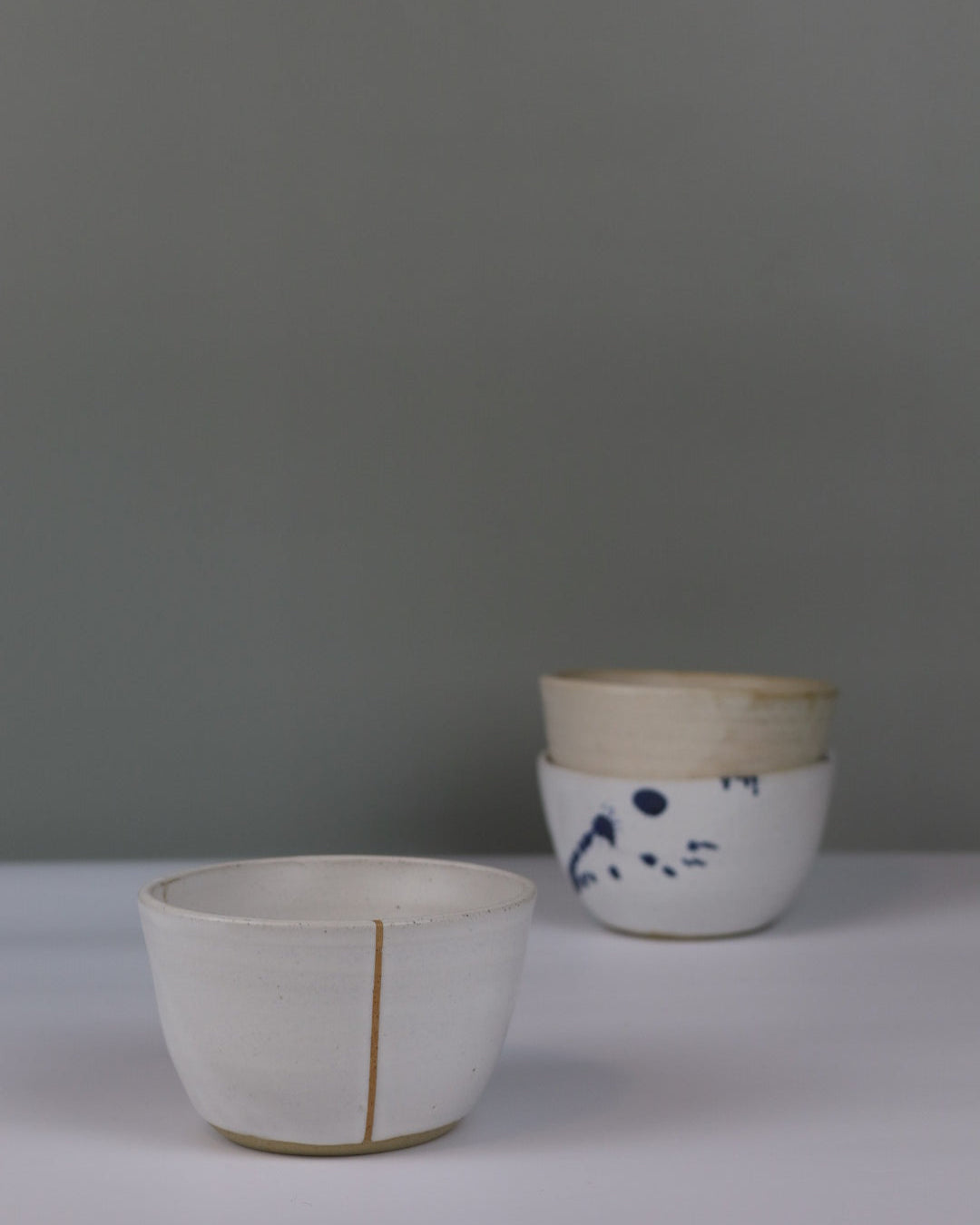 three small bowls in different colours on a grey background