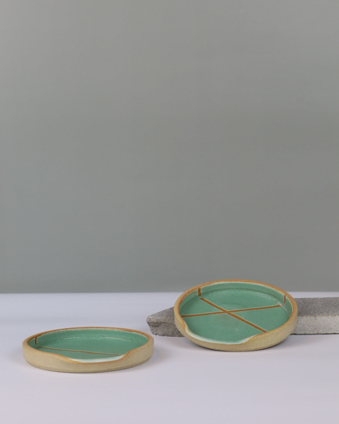 two ceramic spoon rests on a benchtop