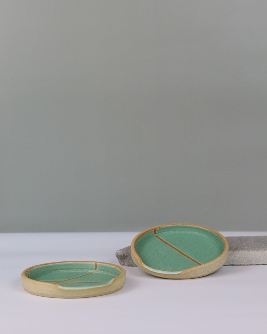 two ceramic spoon rests on a benchtop