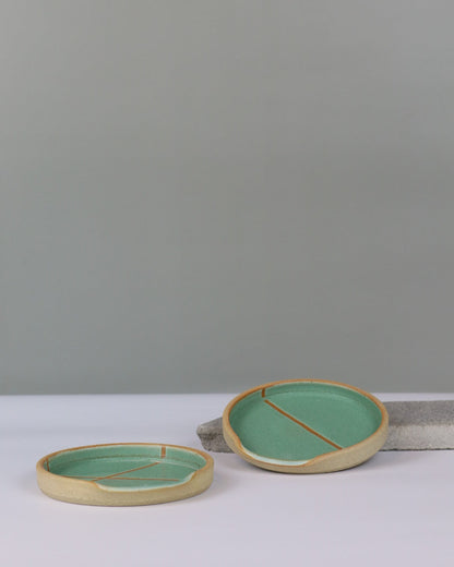 two ceramic spoon rests on a benchtop