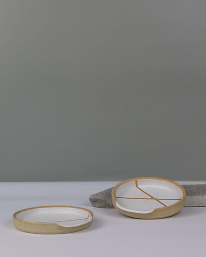 two white ceramic spoon rests on a benchtop