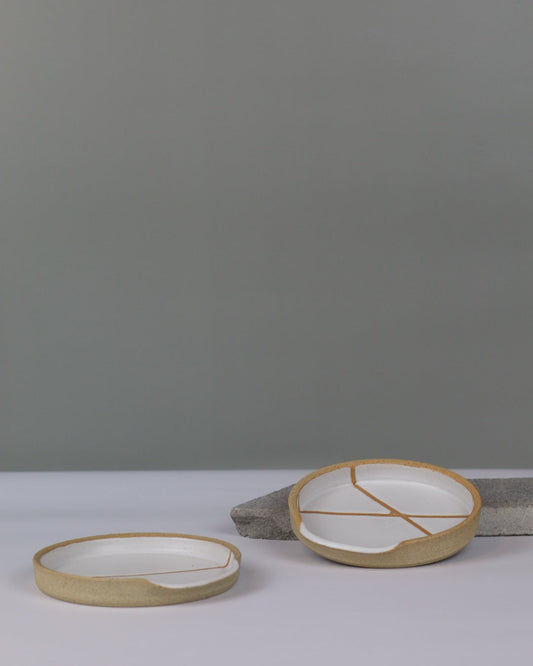 two white ceramic spoon rests on a benchtop