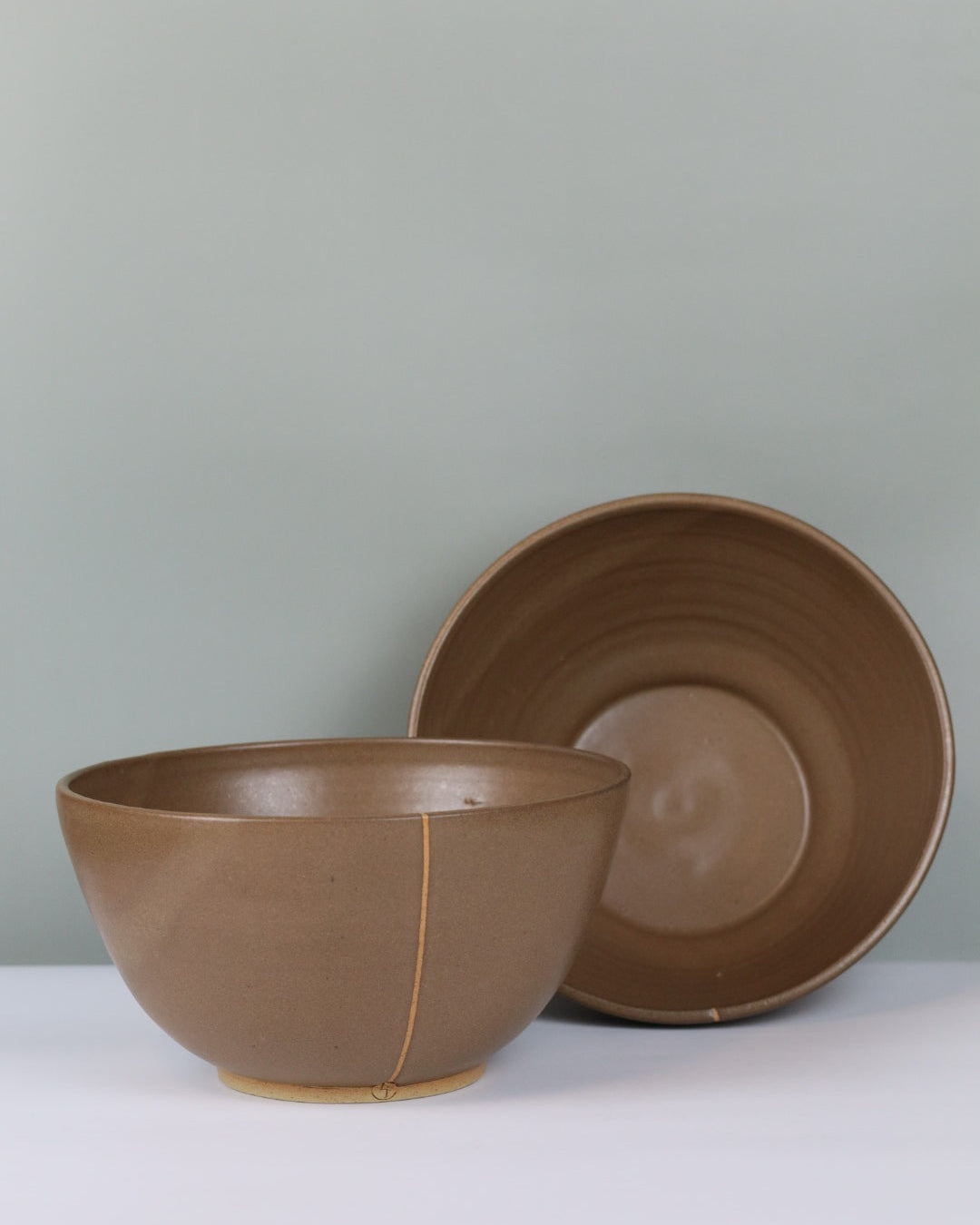 Brown ceramic bowls on a grey background