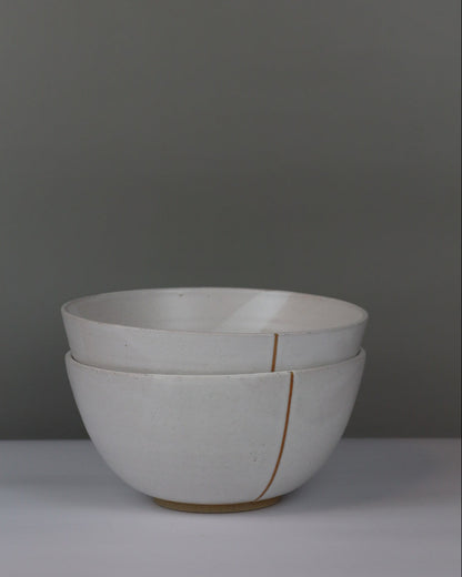 two white ceramic bowls on a grey background